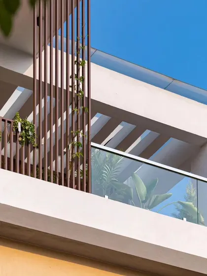A close-up of the upper levels of the Sarjapur home, showing the pergola detail and the interplay of light and shadow on the facade.