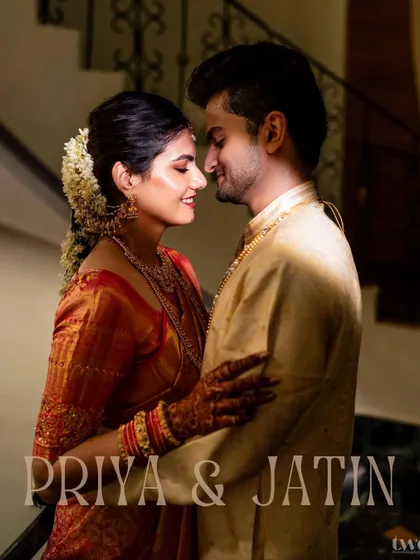 An intimate portrait of a South Indian couple, their smiles reflecting a deep connection. The traditional attire and warm lighting create a feeling of timeless romance and cultural richness.