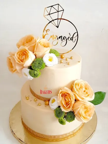 Another take on my popular peach floral engagement cake design. This two-tier, no-fondant beauty is decorated with fresh peach roses and a custom "Engaged" topper, making it a timeless choice for any celebration.