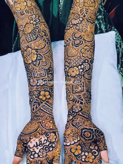 A full view of Raazia's bridal henna. The design is symmetrical but with unique details on each hand, including her name beautifully written on the palm.