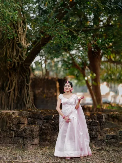 A serene portrait of the bride-to-be in her Haldi attire, standing gracefully in a natural, rustic setting.