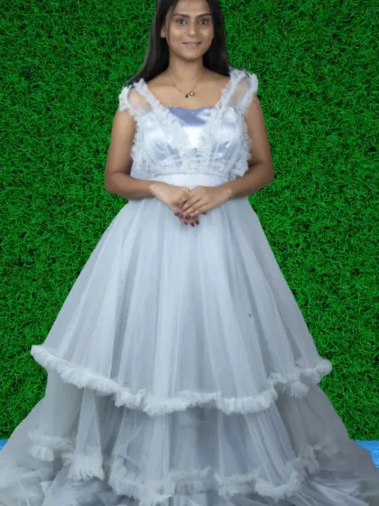 An elegant white tiered gown with delicate ruffle details on the bodice and skirt. It's a beautiful choice for pre-wedding shoots or Christian weddings.