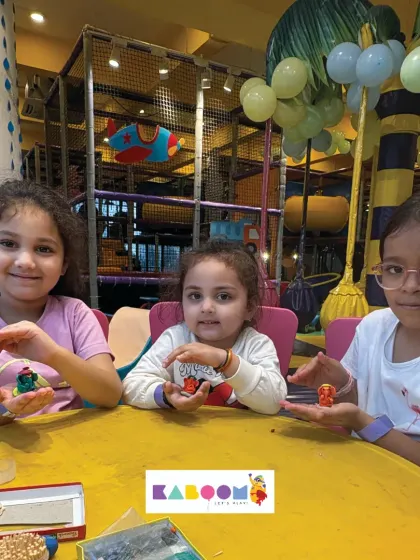 Teamwork makes the dream work! Three friends show off the clay Ganesha idols they made together at our craft table, surrounded by all the tools for a fun, creative session.