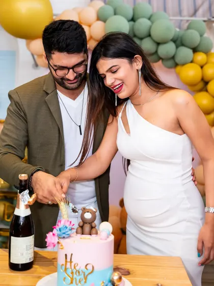 The cake cutting is a central part of any celebration. Here, the happy couple cuts their gender reveal cake at their baby shower, surrounded by modern, elegant decorations.