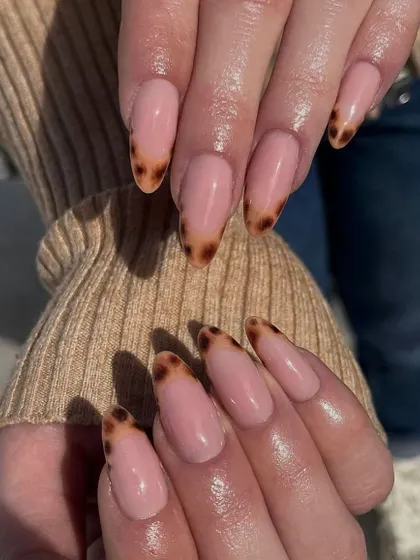 A sophisticated take on animal print. This French manicure features a classic nude base with hand-painted tortoise shell tips.