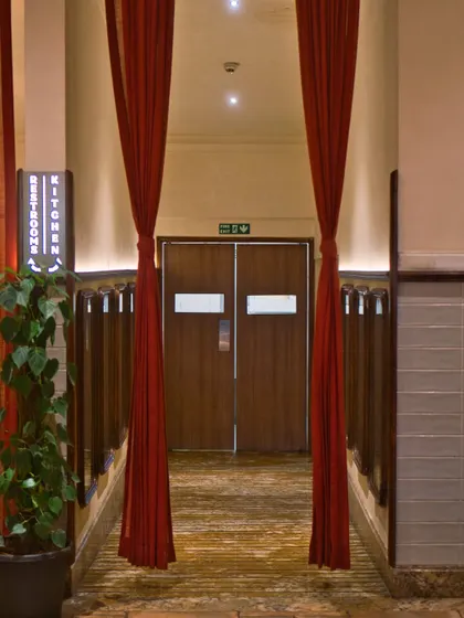 The dramatic entrance to our kitchen, framed by red curtains. This is where the magic begins, a space defined by feeling as much as function.