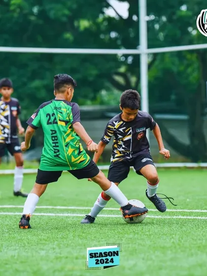 A fierce battle for the ball between two young players in the MDL Tournament.