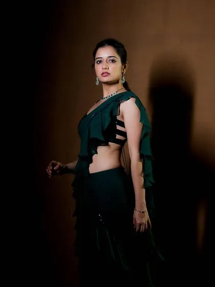 This shot captures the edgy side of my green saree gown design. The layered ruffles are paired with a modern blouse featuring a caged, strappy back detail.