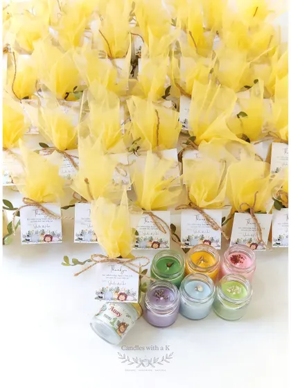 A large order of jungle-themed first birthday return gifts, featuring assorted scented mini soy wax jar candles.