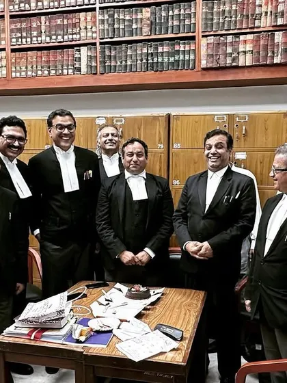 A group of smiling colleagues at ML Yadav's birthday celebration in the bar room. Recognizing the hard work of our peers is part of our professional culture.