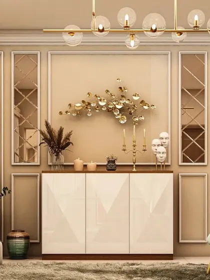 A sophisticated dining room sideboard with a geometric 3D-patterned facade. The wall behind features classic molding and is accented with modern brass sconces and a sculptural metal wall art piece.