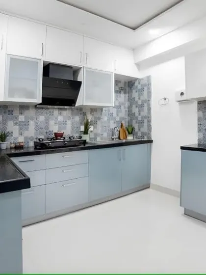 This kitchen uses two tones of blue-grey with a beautiful patterned tile backsplash. The layout provides plenty of counter space and storage, making it a dream for anyone who loves to cook.