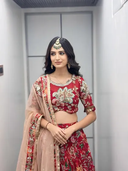 Her red floral lehenga is the star of the show, so we kept the makeup and hair simple and chic to complement it.