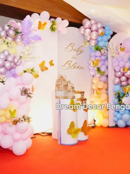 A 'Baby in Bloom' baby shower with a butterfly theme. The pastel balloon arrangements in pink, purple, and blue create a soft and dreamy atmosphere.