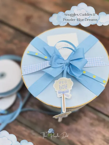 The top view of the blue hat box, showcasing the intricate bow I created using a mix of gingham, polka-dot, and satin ribbons for a textured, celebratory finish.