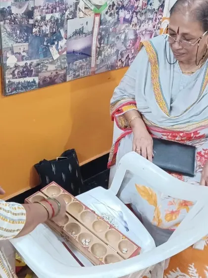 An educator demonstrating how to use the traditional game of Palanguzi in a workshop focused on innovative teaching methods.