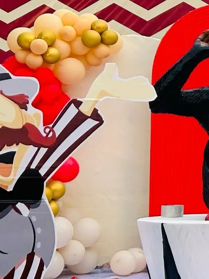 Fun and quirky details from a carnival party, including a ringmaster and monkey cutout that add character and charm to the event.