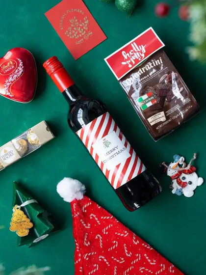 The contents of the 'Jolly Feast' hamper laid out on a green background, ready for gifting.