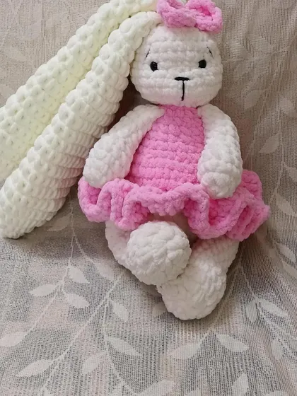 Made with super-soft, thick yarn, this long-eared bunny in a pink dress is designed to be extra floppy and cuddly.