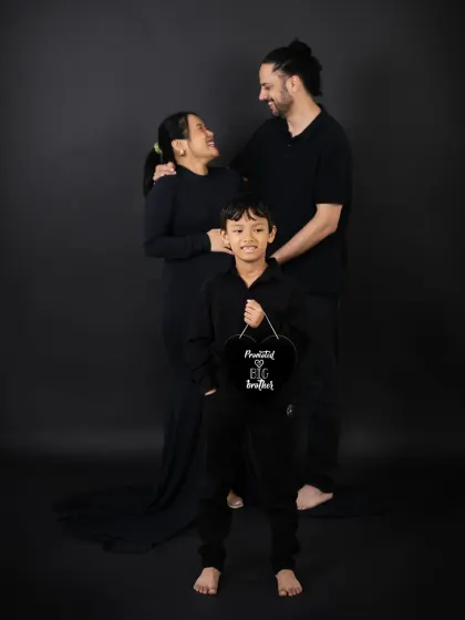 The whole family is excited for the new arrival. This portrait captures the parents and soon-to-be big brother looking forward to their family growing by two more feet.