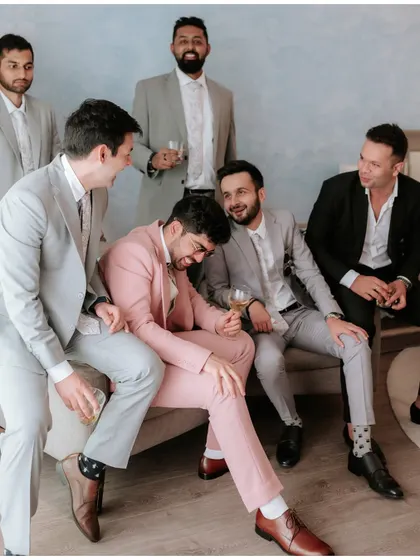 The groom sharing a laugh with his best men. The camaraderie and fun of the groom's squad is an essential part of the celebration.