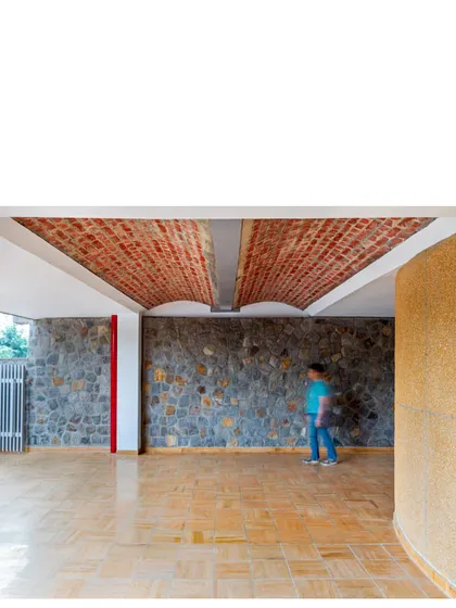 At the street level, a load-bearing double brick vault welcomes visitors, while the random rubble wall extends the full height of the building, emphasizing continuity.