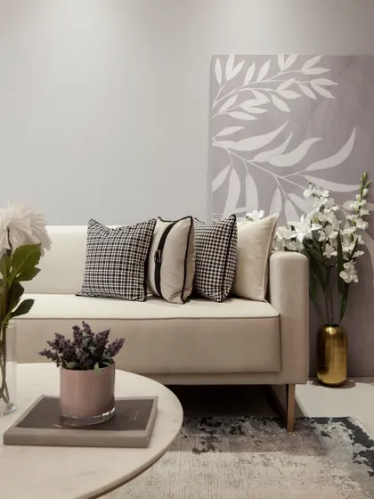 A closer look at a living area where we used a soft, neutral palette to create a calming atmosphere. The space is brought to life with floral arrangements and carefully chosen cushions, including classic houndstooth patterns, adding texture and a timeless feel.