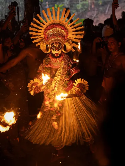 A series showing the Karim Gullikan Theyyam performance, surrounded by devotees and fire. These images document the energy of the crowd and the deity's commanding presence during the ritual.