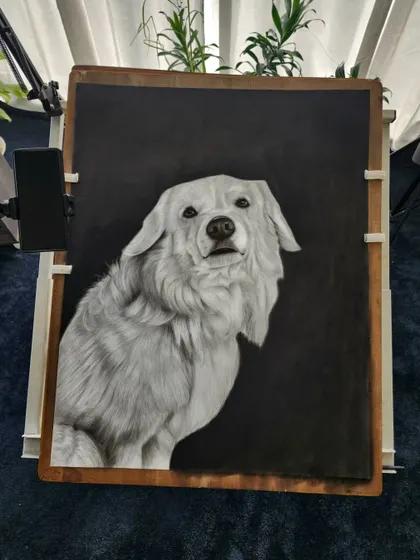 The finished dog portrait on the easel, with a dark background that makes the white fur stand out.