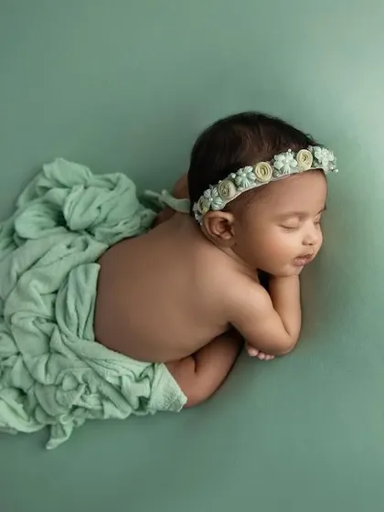 A top down view of the 'taco' pose, with a soft green wrap draped elegantly.