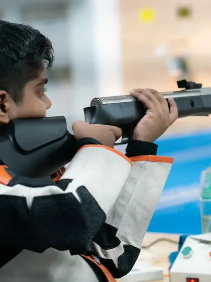 A young shooter takes aim with an air rifle. We provide training for grassroots-level athletes, helping them build a strong foundation for a future in competitive shooting.