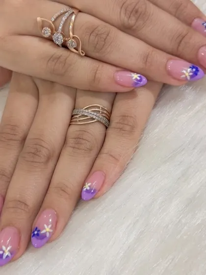 Soft, dreamy, and perfect for any occasion. This design features a gentle purple ombré fade on almond-shaped extensions, finished with tiny, hand-painted white and yellow flowers.