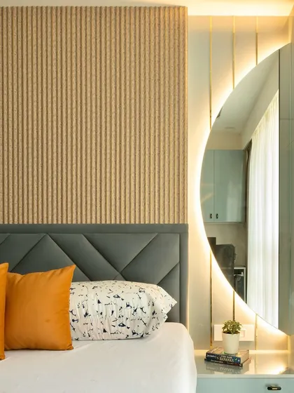 A close-up of the bedroom's design, showing a backlit circular mirror that doubles as a statement piece and a functional part of the dressing area.