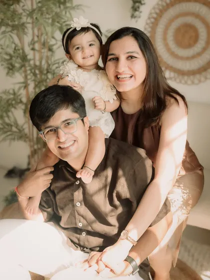 A playful family portrait with the toddler perched on her dad's shoulders.