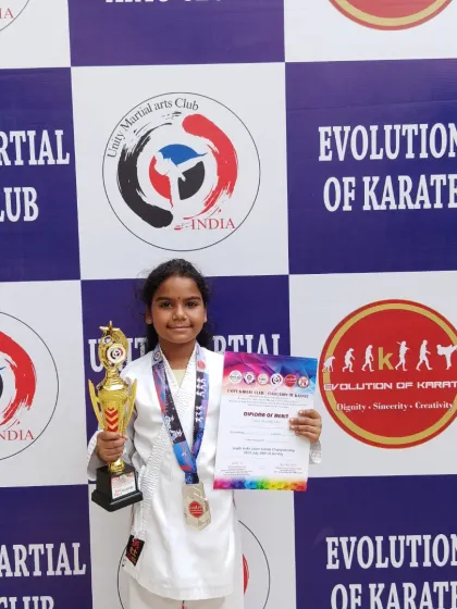 A young female student proudly displays her trophy and certificate. I encourage and train girls to be strong, confident, and capable martial artists.
