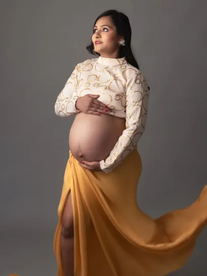 I love combining different fabrics and textures. Here, a patterned top is paired with a flowing yellow skirt against a simple grey background for a unique and stylish portrait.