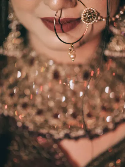 A close-up, artistic shot focusing on the bride's nath and lips, with a beautiful bokeh effect.