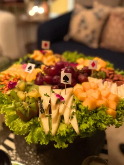 A fun, themed grazing platter designed for a Diwali taash party. This spread features a variety of cheeses, fruits, and nuts, playfully decorated with card suit markers, making it a perfect snack station for a night of games.