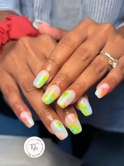 A fun, abstract watercolor-style manicure. This design uses splashes of bright neon colors over a milky white base to create a vibrant, artistic look perfect for summer.