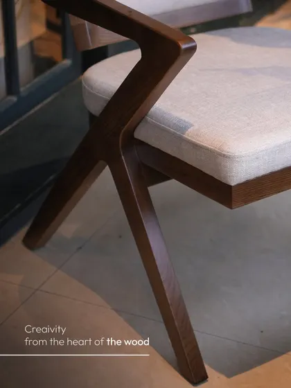 A close-up on the cross-leg construction of our Z-frame chair, showcasing the creativity that comes from the heart of the wood. The grain and finish are a testament to our attention to detail.