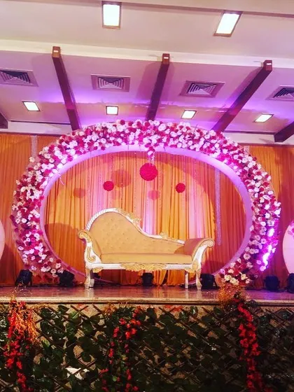 I love creating unique, custom stage designs like this circular floral frame. The structure, adorned with pink and white flowers, offers a modern and artistic alternative to a traditional rectangular stage.
