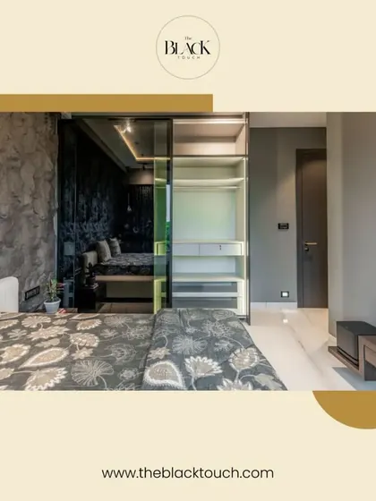 A stylish bedroom with a dark, textured wall and a glass-paneled wardrobe. The design is modern and sophisticated, creating a moody yet comfortable ambiance.