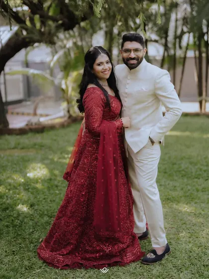 A classic portrait of a couple in their reception attire, posing in a garden setting.