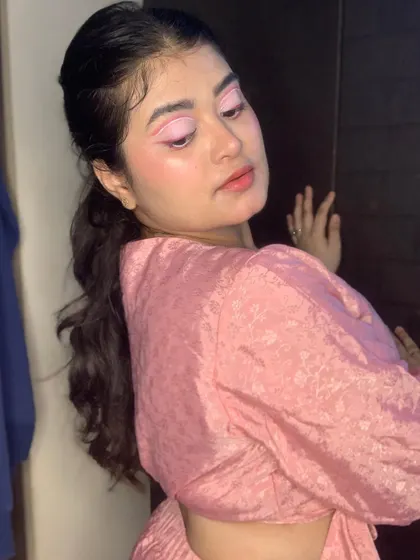 A pretty-in-pink look with a creative graphic eyeliner and a high ponytail.
