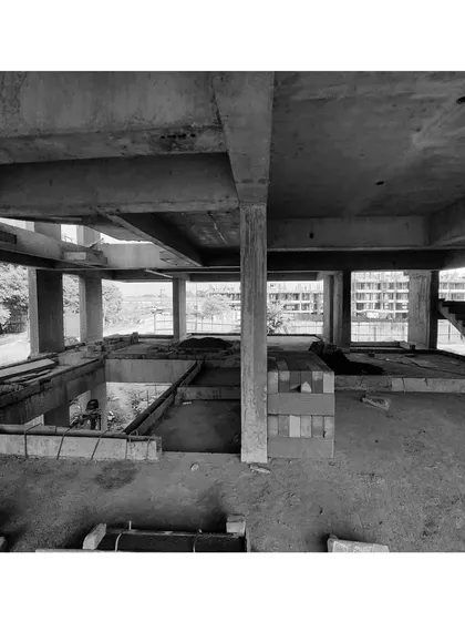 An internal black and white shot of the Aamod project under construction, showing the raw concrete structure before blockwork begins.