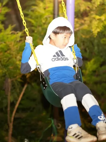 A young player on the swings, enjoying a moment of relaxation during the tour.