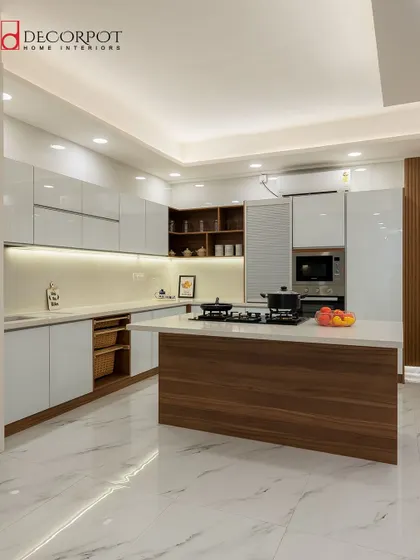 An elegant L-shaped kitchen featuring a mix of wood-finish and white cabinets. The island with a wooden base adds warmth and provides extra workspace, making it both beautiful and practical.