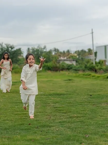 A dynamic action shot of two kids running freely and joyfully across a lawn. We let children lead the way in our outdoor shoots, ensuring we capture their natural energy and spirit.