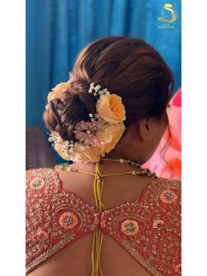 A truly timeless bun adorned with delicate peach roses, baby’s breath, and tiny butterflies. This hairstyle captures the essence of romance and beauty for a special day.