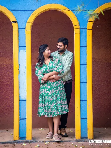 A lovely portrait of a couple framed within colorful arches, creating a vibrant and happy image.